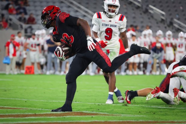Cincere Rhaney #23 of the San Diego State Aztecs runs the ball in for a touchdown against DaMario Crawford #9 of the Stony Brook Seawolves during the second half at Snapdragon Stadium on Thursday, Aug. 28, 2025 in San Diego, CA. (Meg McLaughlin / The San Diego Union-Tribune)