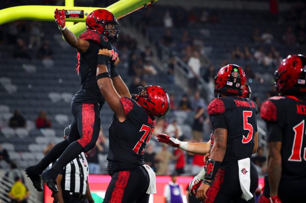 Cincere Rhaney #23 and Michael Leville Watkins #75 of the San Diego State Aztecs celebrate after Rhaney's touchdown against Stony Brook during the second half at Snapdragon Stadium on Thursday, Aug. 28, 2025 in San Diego, CA. (Meg McLaughlin / The San Diego Union-Tribune)