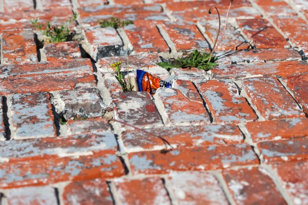 Trash is seen inside the crumbling brick pedestal where "The Black Family" once stood at Mountain View Community Park on Thursday, July 31, 2025. (Meg McLaughlin / The San Diego Union-Tribune)