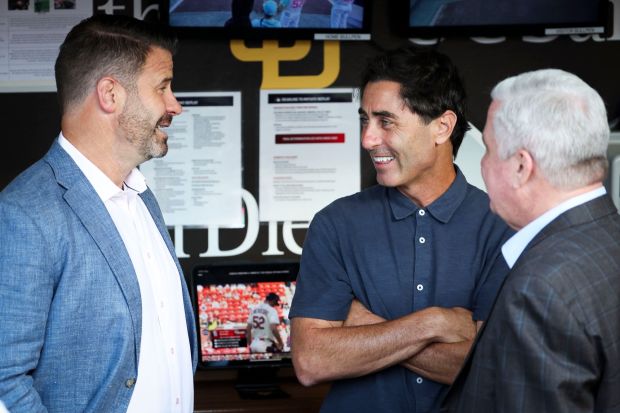San Diego Padres CEO Erik Greupner, President of baseball operations A.J. Preller and Chairman and Control Person John Seidler chat in the dugout before the game against the St. Louis Cardinals at Petco Park on Friday, Aug. 1, 2025 in San Diego, CA. (Meg McLaughlin / The San Diego Union-Tribune via Getty Images)