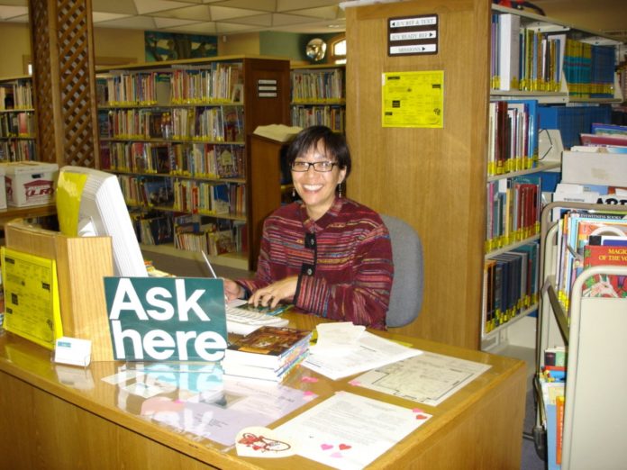 Photo Courtesy of South Pasadena Public Library | The South Pasadenan | Public Services Manager Maida Wong sits behind the reference desk at South Pasadena Library. Wong is retiring after working at the library over the past 37 years.