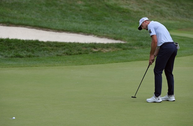 Sam Burns makes a birdie putt on the ninth hole...