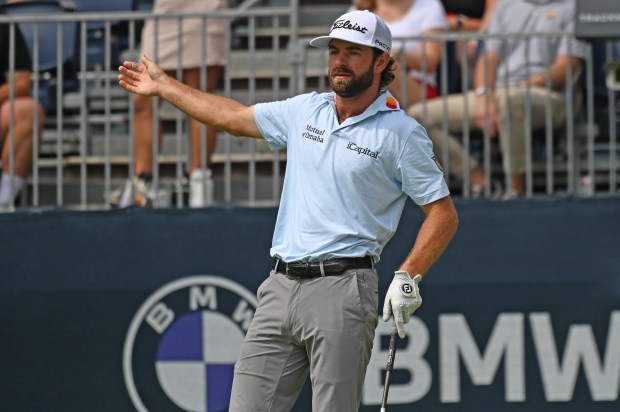 Cameron Young gestures after he tees off to start his...