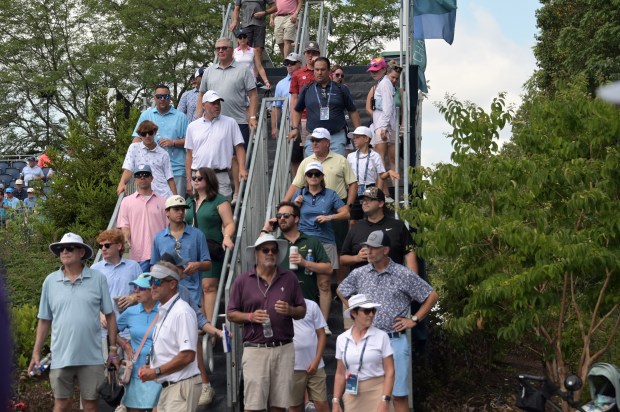Spectators leave their seats at the first tee during the...