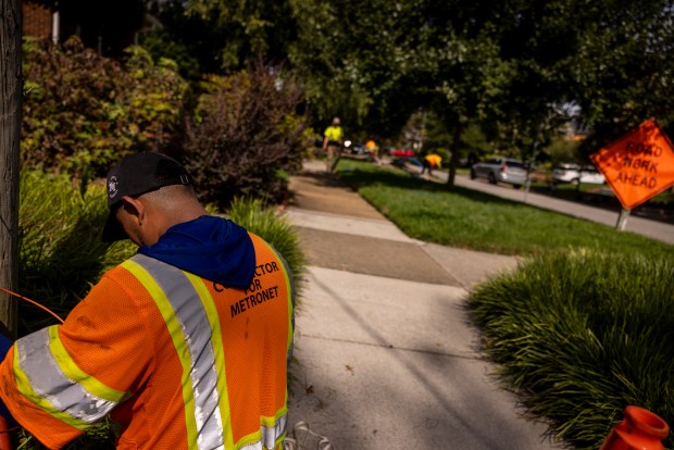 Workers install Metronet infrastructure is installed in the Ghent neighborhood of Norfolk, Virginia, on Aug. 14, 2025. (Billy Schuerman / The Virginian-Pilot)