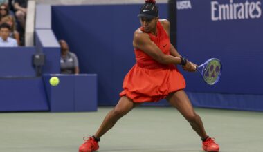 Naomi Osaka playing tennis in a red outfit