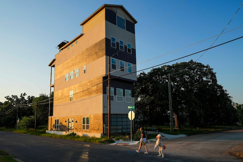 A woman walks a dog past a 5-story, 4,293 square foot, unfinished townhouse at 1401 Seegar...