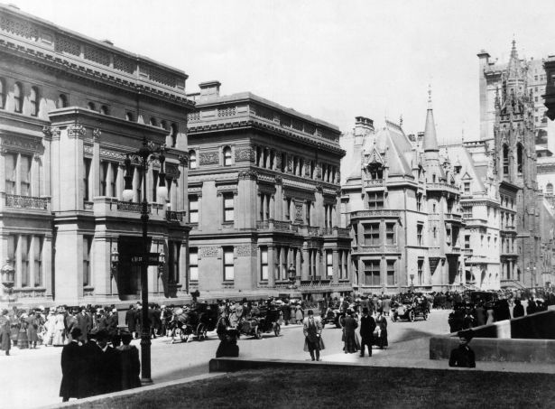 Pedestrians, cars and coaches passing in front of Vanderbilt Mansion on Fifth Avenue in New York in the early 1900s.