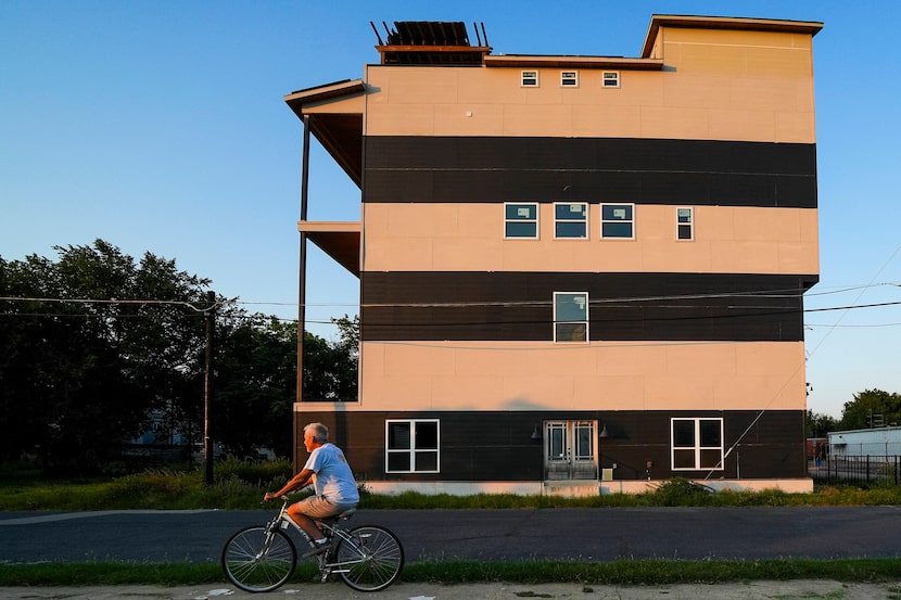 Chris Henry, who lives a few blocks away, rides his bike past a 5-story, 4,293 square foot,...