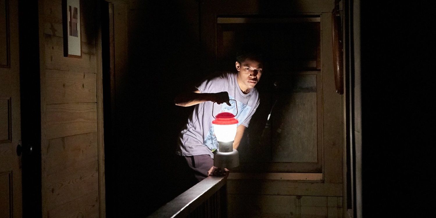 A young man holds a lantern in It Comes At Night