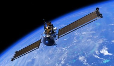 a cube-shaped spacecraft with two long wing-like solar panels in orbit above earth