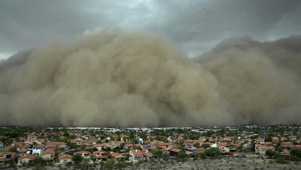 A towering wall of dust has rolled through metro Phoenix with storms that left tens of thousands of people without power and delayed flights at the city airport