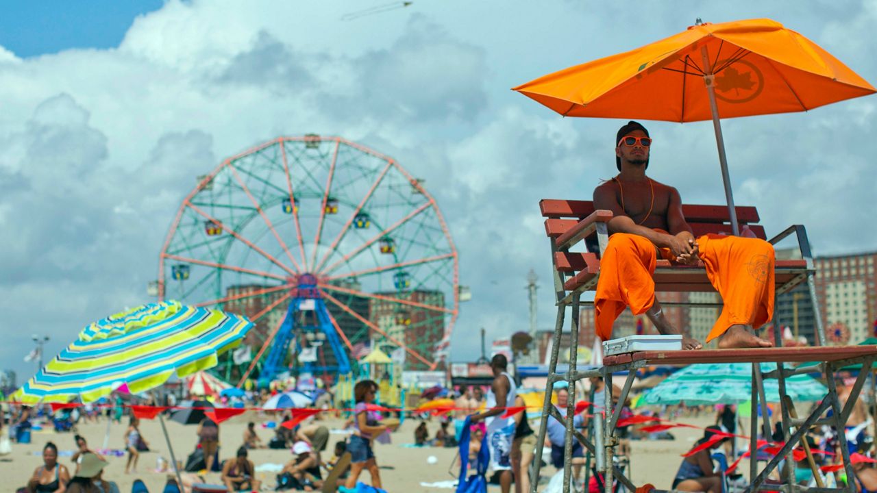 The lifeguard keeps an eye on the swimmers, Saturday, Aug. 20, 2016, on Coney Island in the Brooklyn borough of New York. (AP Photo/Mary Altaffer)