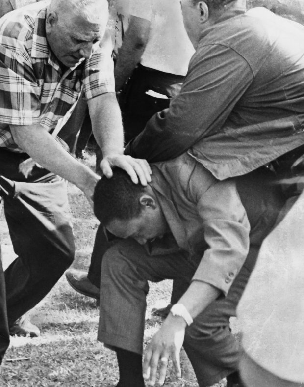 Aides shield the Rev. Martin Luther King Jr. after he was struck by a rock in Marquette Park during an Aug. 5, 1966, march in Chicago. (Chicago Tribune historical photo) 