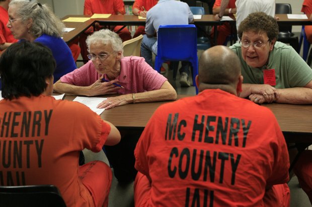 Sisters Pat Murphy, left, and JoAnn Persch, right, speak with immigration detainees at the McHenry County Jail, on July 21, 2009. They led a group of religious workers in ministering to the detainees' spiritual needs in a library at the jail. (Alex Garcia/Chicago Tribune) 