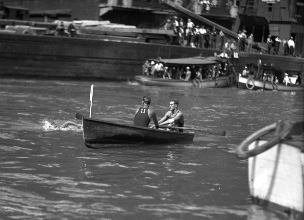 Swim race contestant Johnny Weissmuller swims in the river while being closely followed by Lincoln Park life guard Pete Weissmuller in 1926. (Chicago Herald and Examiner) 