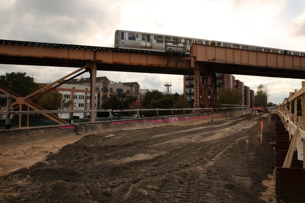 A CTA Blue Line train passes above a former rail...