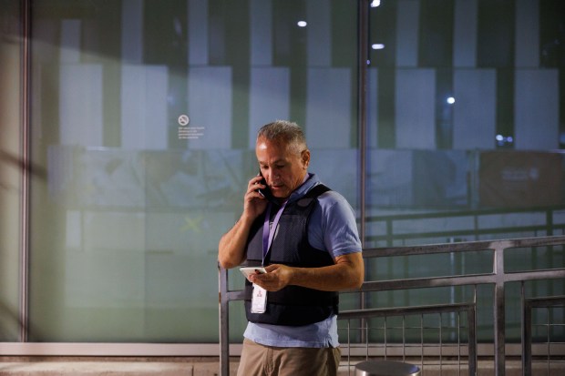 Crisis responder Jose Hernadez waits to talk with family members after a 27-year-old man was fatally shot near the 3500 block of South Rhodes and brought to the University of Chicago Medical Center on Aug. 6, 2025, in Chicago. (Armando L. Sanchez/Chicago Tribune)