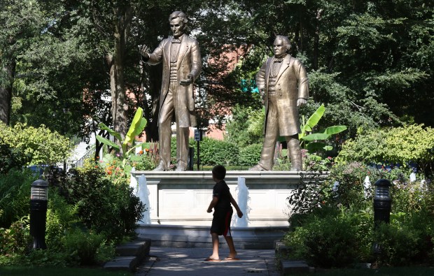 A child stands in front of statues of Abraham Lincoln, left, and Stephen A. Douglas in Ottawa, Illinois. The park is where they first debated. (John J. Kim/Chicago Tribune)