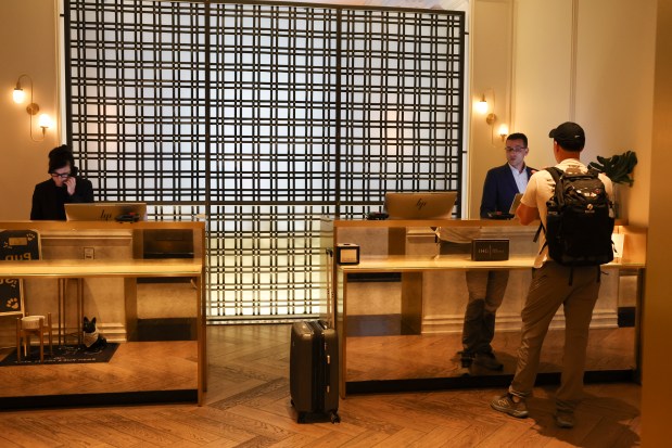 A hotel receptionist helps a guest in the lobby of...