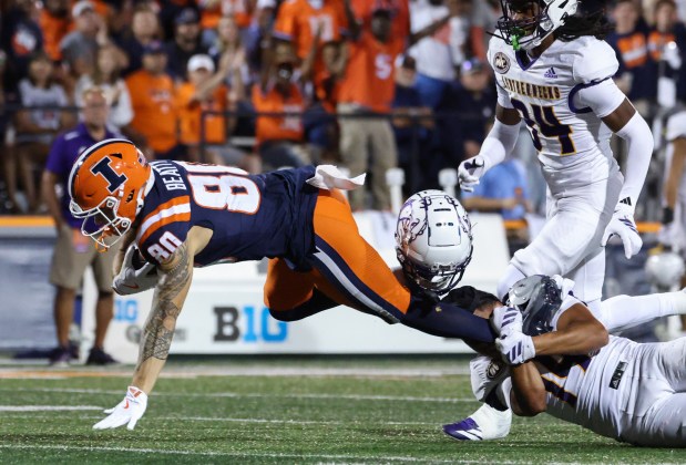 Western Illinois defensive back Buju Aumua-Tuisavura (14) loses his helmet while tackling Illinois wide receiver Hank Beatty (80) in the second quarter at Memorial Stadium on Aug. 29, 2025, in Champaign. (John J. Kim/Chicago Tribune)