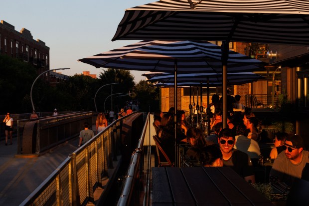 People sit on the Wolf & Company restaurant patio near...