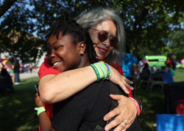 Leah Tucker, 13, is hugged by Maria Pike, a gun violence survivor advocate, during a National Night Out event at Ogden Park in the Englewood neighborhood of Chicago, Aug. 5, 2025. (John J. Kim/Chicago Tribune)