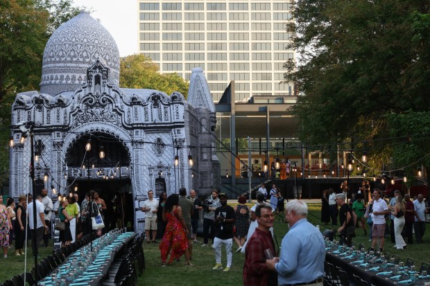 Guests stand near an entrance to the Floating Museum art collective's "for Mecca" installation at the north lawn of S.R. Crown Hall on the IIT campus, Aug. 8, 2025, in Chicago. (John J. Kim/Chicago Tribune)