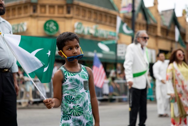 Zakaria Hussain, 7, holds a flag during the march down West Devon Avenue to celebrate Pakistan Independence Day on Aug. 10, 2025, in Chicago's West Rogers Park neighborhood. (Brian Cassella/Chicago Tribune)