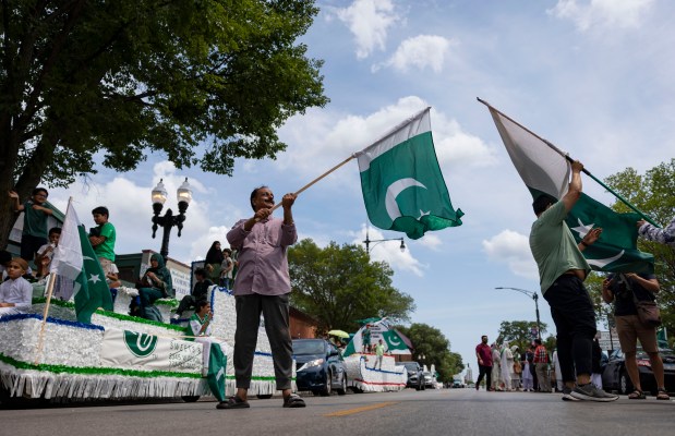 M. Rafiq holds a flag as participants prepared to march down West Devon Avenue to celebrate Pakistan Independence Day on Aug. 10, 2025, in the West Rogers Park neighborhood of Chicago. The annual event, complete with floats and music, commemorates the day Pakistan achieved independence from the British colonial rule in 1947. (Brian Cassella/Chicago Tribune)