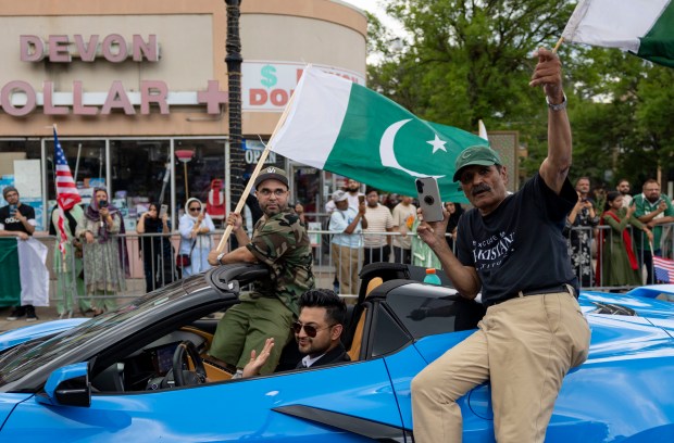 Participants ride on a car down West Devon Avenue to celebrate Pakistan Independence Day on Aug. 10, 2025, in the West Rogers Park neighborhood of Chicago. (Brian Cassella/Chicago Tribune)