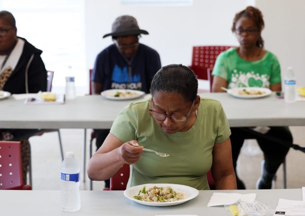 Cheryl Johnson and other residents at Mercy Commons housing development eat a meal of chicken and vegetables prepared in a cooking demonstration on Aug. 12, 2025. (Terrence Antonio James/Chicago Tribune)