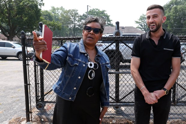 Chicago Ald. Michelle Harris, 8th, left, talks to business owner Mahmoud Shaltaf about his convenience store in the 1900 block of E. 87th Street in Chicago, July 31, 2025. Harris supports a push to have fewer ads covering the windows of retail businesses. (Terrence Antonio James/Chicago Tribune)