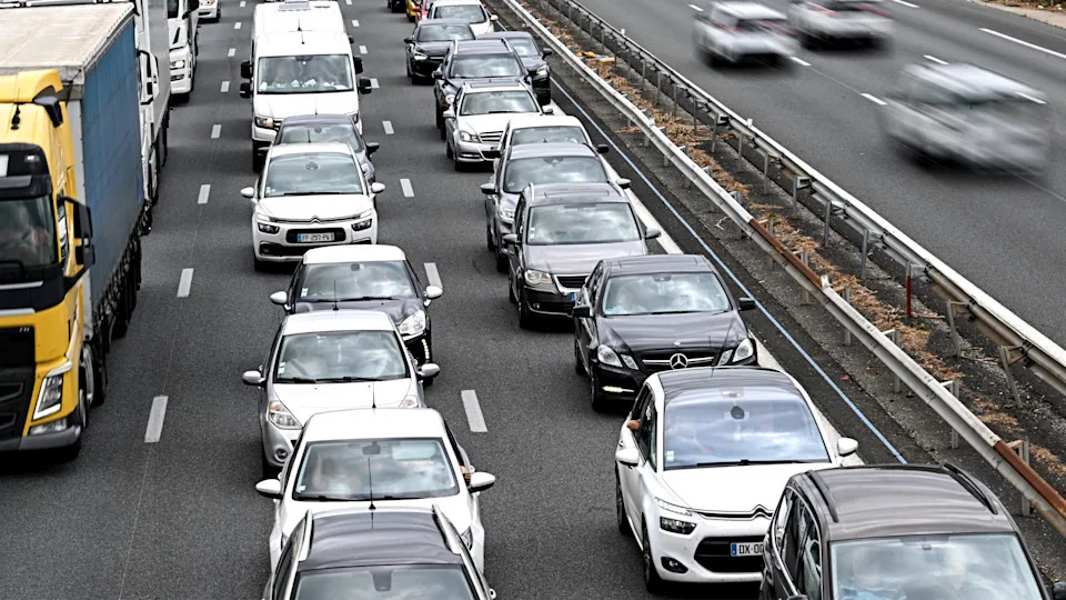 Heavy traffic on a multi-lane highway, with cars, trucks, and vans moving slowly.