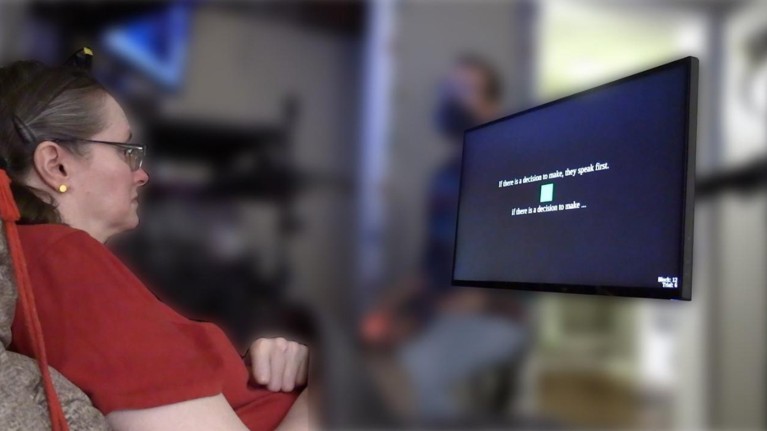A participant in a red T-shirt looks at a screen that is displaying the words 'If there is a decision to make, they speak first.'