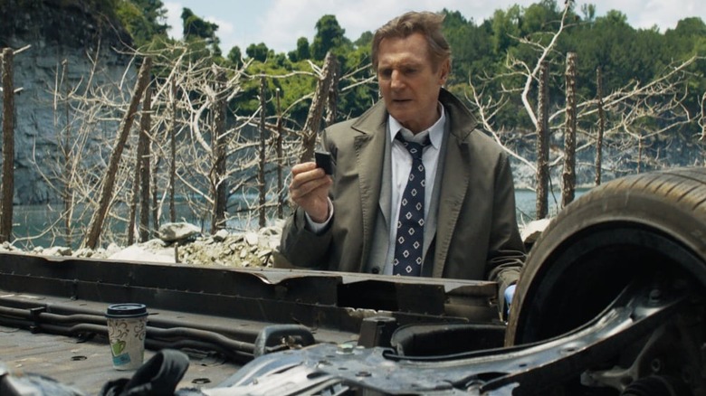 Frank Drebin next to an overturned car in The Naked Gun (2025)