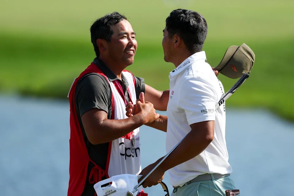 Kurt Kitayama celebrates with caddie Daniel Kitayama after winning the 3M Open golf tournament.