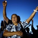 ALTADENA, CALIFORNIA - JULY 07: People attend a memorial service honoring the 19 lives lost during Eaton Fire on July 07, 2025 in Altadena, California. The memorial service was held at the edge of the property where Evelyn McClendon, 59, lived before losing her life in the fire. Today is the six-month anniversary of the Eaton and Palisades fires which claimed 30 lives and left more than 16,000 structures destroyed. (Photo by Mario Tama/Getty Images)