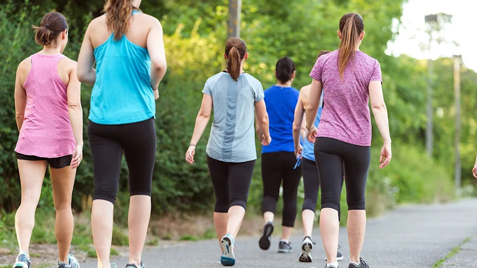 Women walking in a group with their backs facing the camera.