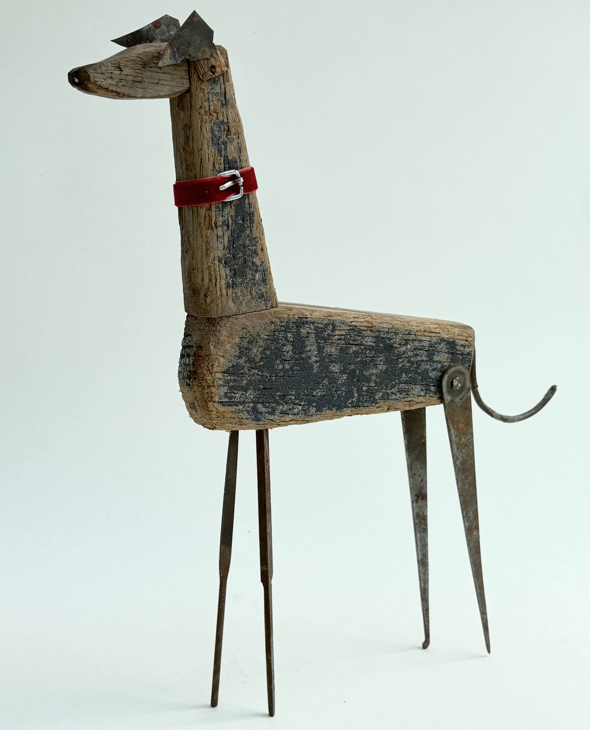 a dog sculpture made of worn blue and brown wood