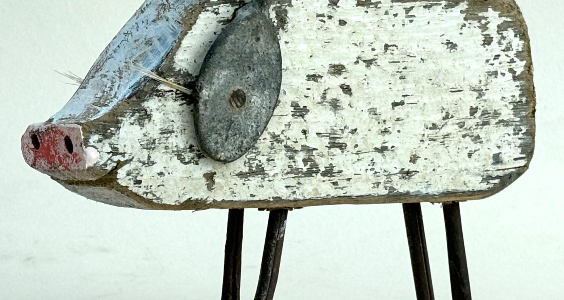 a pig sculpture made of worn white wood