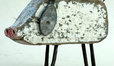 a pig sculpture made of worn white wood