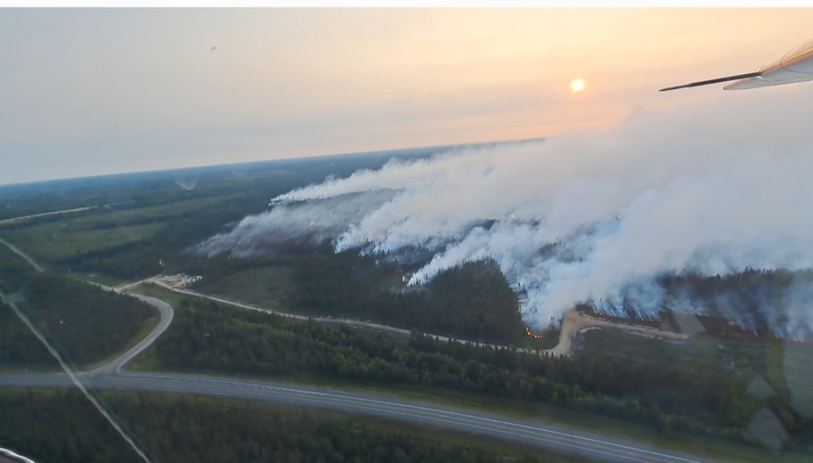 Large smoke clouds from a fire in the woods.