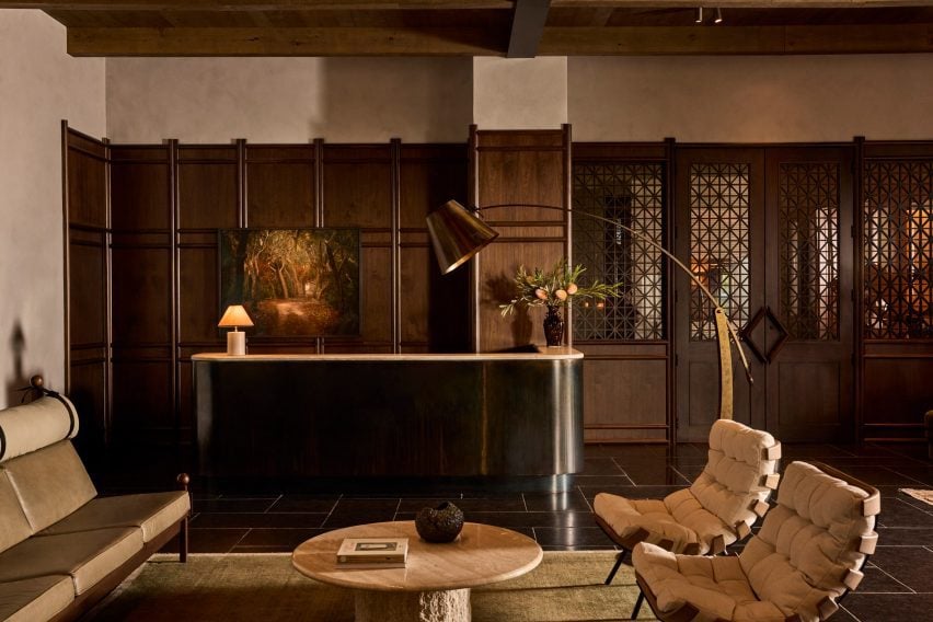 Dark wood panelling installed against textured plaster across a hotel lobby's walls