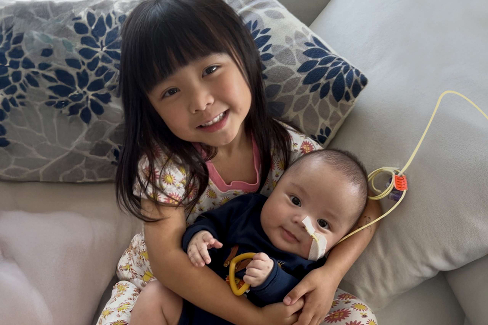 Young girl holding a baby in her arms