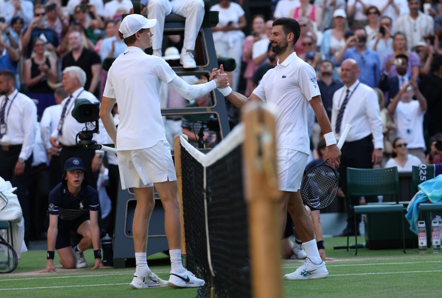 Sinner meets Novak Djokovic at the net after winning their semifinal match at Wimbledon this year.