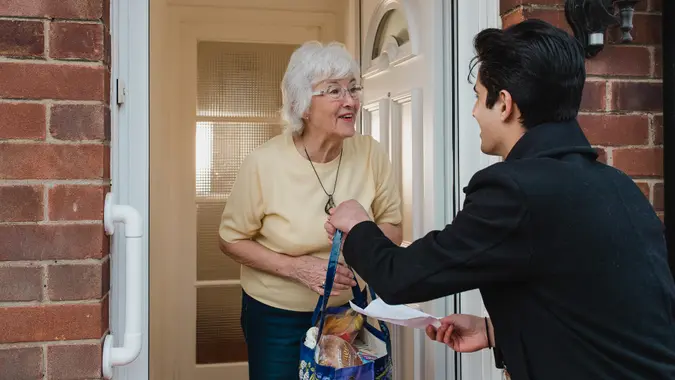Teenage boy is delivering groceries to his grandmother.