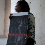 CAMBRIDGE, MA - JUNE 20: Shonrael Lanier, a descendant of former slave Renty Taylor, holds a sign at a press conference held at Harvard University to talk about the lawsuit that the family has filed against the university in Cambridge, MA on June 20, 2019. Under cover from a torrential downpour, two families came together on Harvard Universitys campus Thursday to demand that the institution turn over historical photographs of two slaves and reckon with its history of white supremacy. Tamara Lanier, a Connecticut woman who sued Harvard in March, has said shes a descendant of Renty and his daughter Delia, two slaves who were forced in 1850 to pose naked for daguerreotypes, or early photographs. She said the images, discovered in 1976 and stored in Harvards Peabody Museum, rightfully belong to her, and her lawsuit alleges that Harvard is shamelessly capitalizing on them. She was joined at a press conference Thursday by descendants of controversial Harvard scientist Louis Agassiz, who commissioned the daguerreotypes in an attempt to support his theory of white biological superiority. (Photo by Jonathan Wiggs/The Boston Globe via Getty Images)