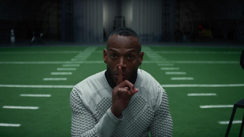 Marlon Wayans as Isaiah White in Him, centered in the frame and putting his finger over his mouth to 