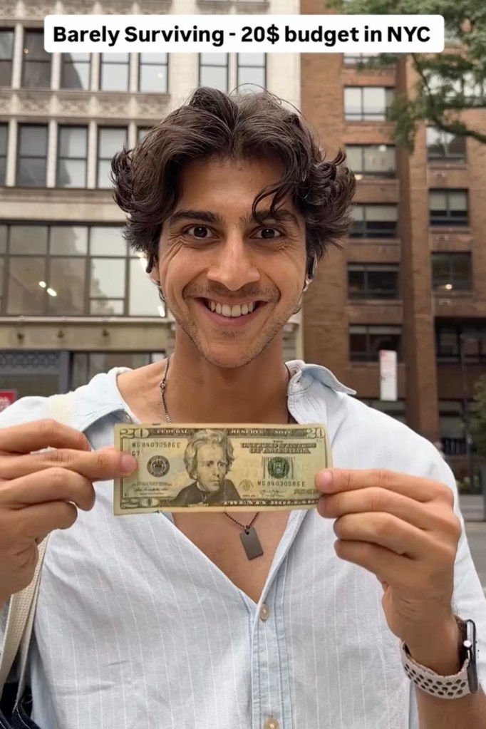 Man in NYC holding a twenty-dollar bill.